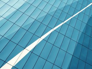 Blue glass facade with diagonal white reflection