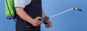 Technician with pesticide sprayer wand