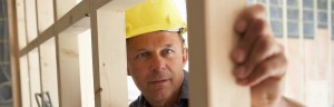 Construction worker inspecting wooden wall framing