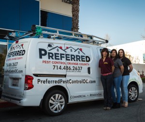 Three women standing beside pest control van
