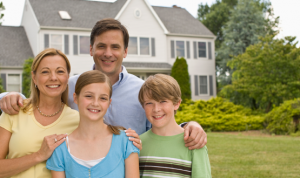 Smiling family of four outside house