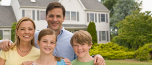 Family of four outside suburban house