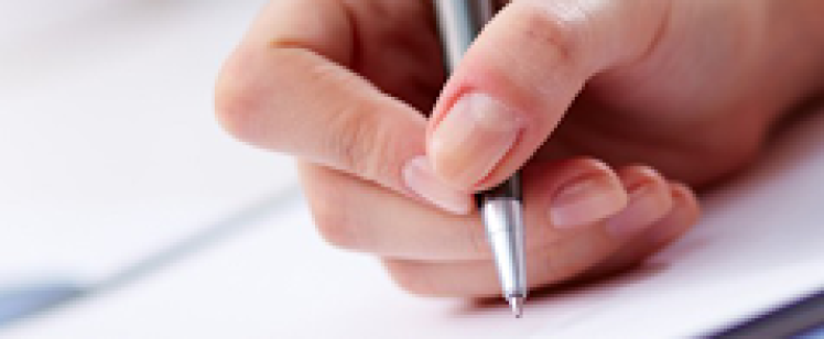 Close-up of hand writing with a pen