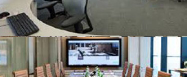 Open-plan office above conference room with floral centerpiece