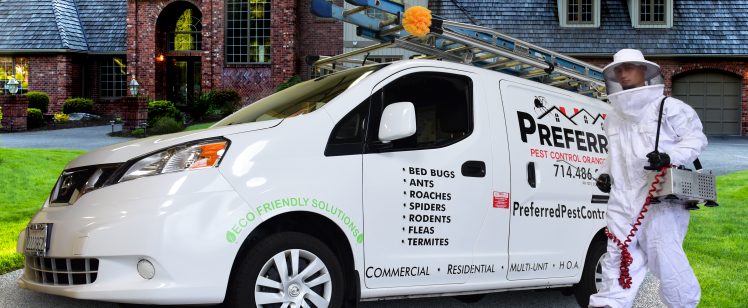 Pest control technician beside service van