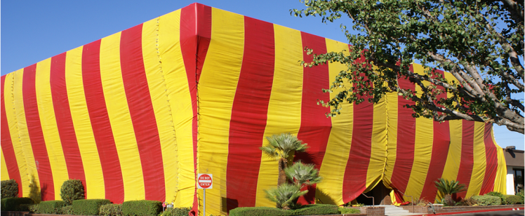 Large building wrapped in red and yellow stripes