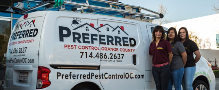 Three women standing beside pest control van
