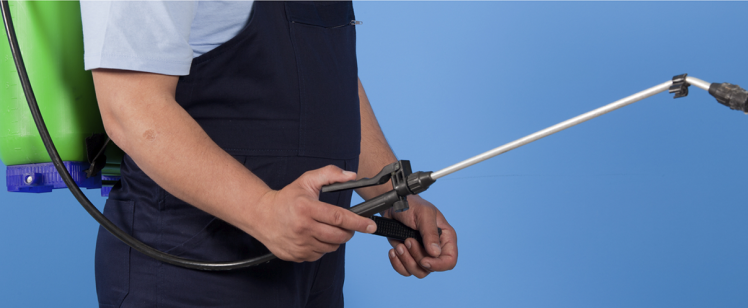 Technician with pesticide sprayer wand