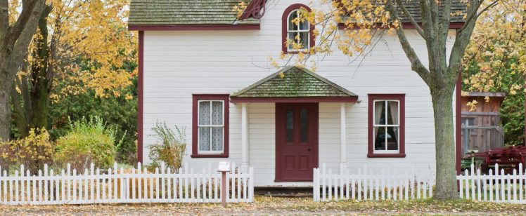 White cottage with picket fence in autumn